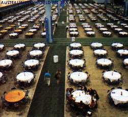 [ 82Kb JPEG Image of large hall with perhaps 200 tables - all empty, except for one. ]